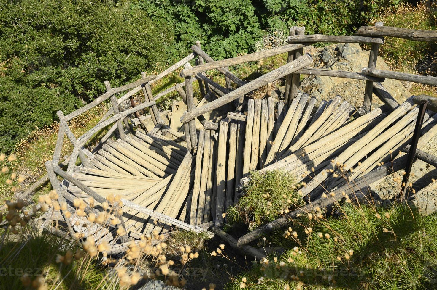 Old homemade wooden staircase that runs over rocks in a mountain gorge photo