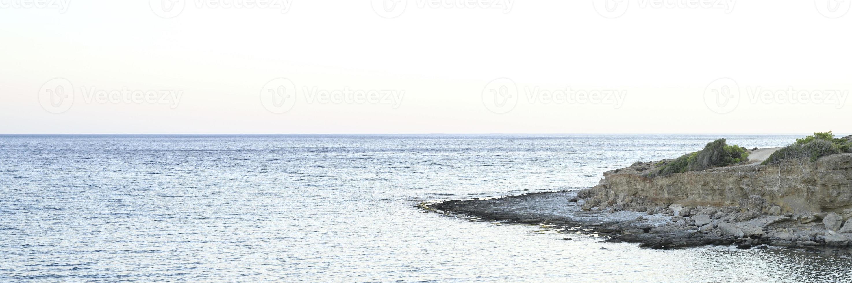 paisaje marino con rocas temprano en la mañana o tarde en la noche foto