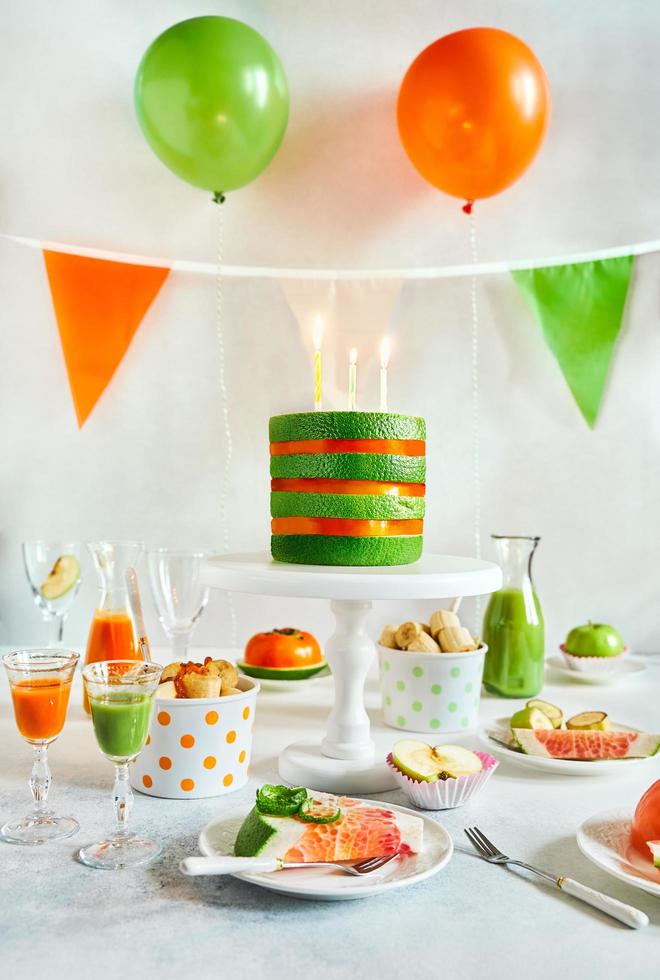 Birthday party table setting with variety of raw fruit as food photo