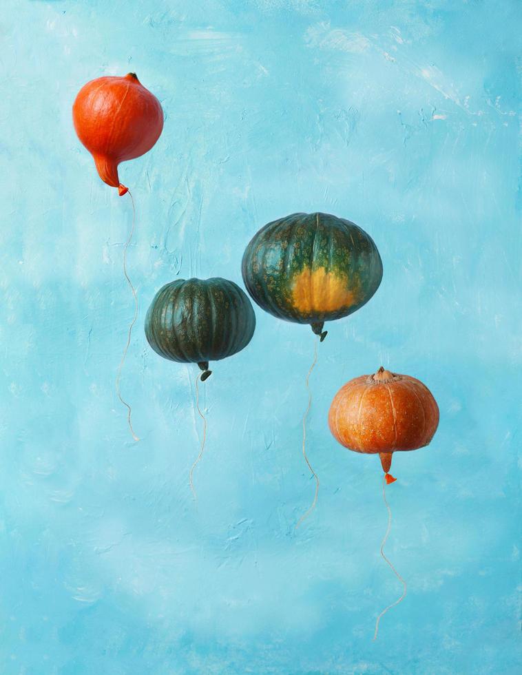 Green and orange pumpkins imitating balloons in the sky photo