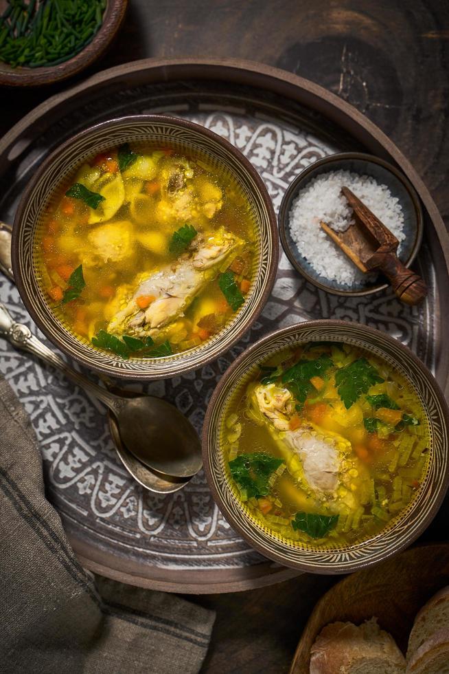 Asian style chicken soup in two clay bowls photo