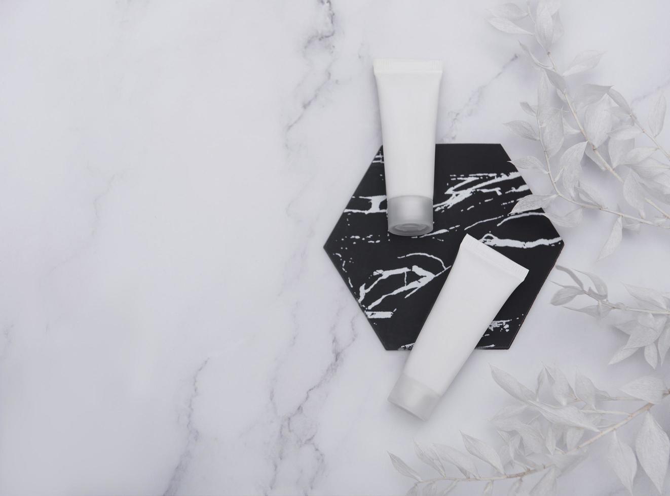 White tubes of cream on a marble background photo