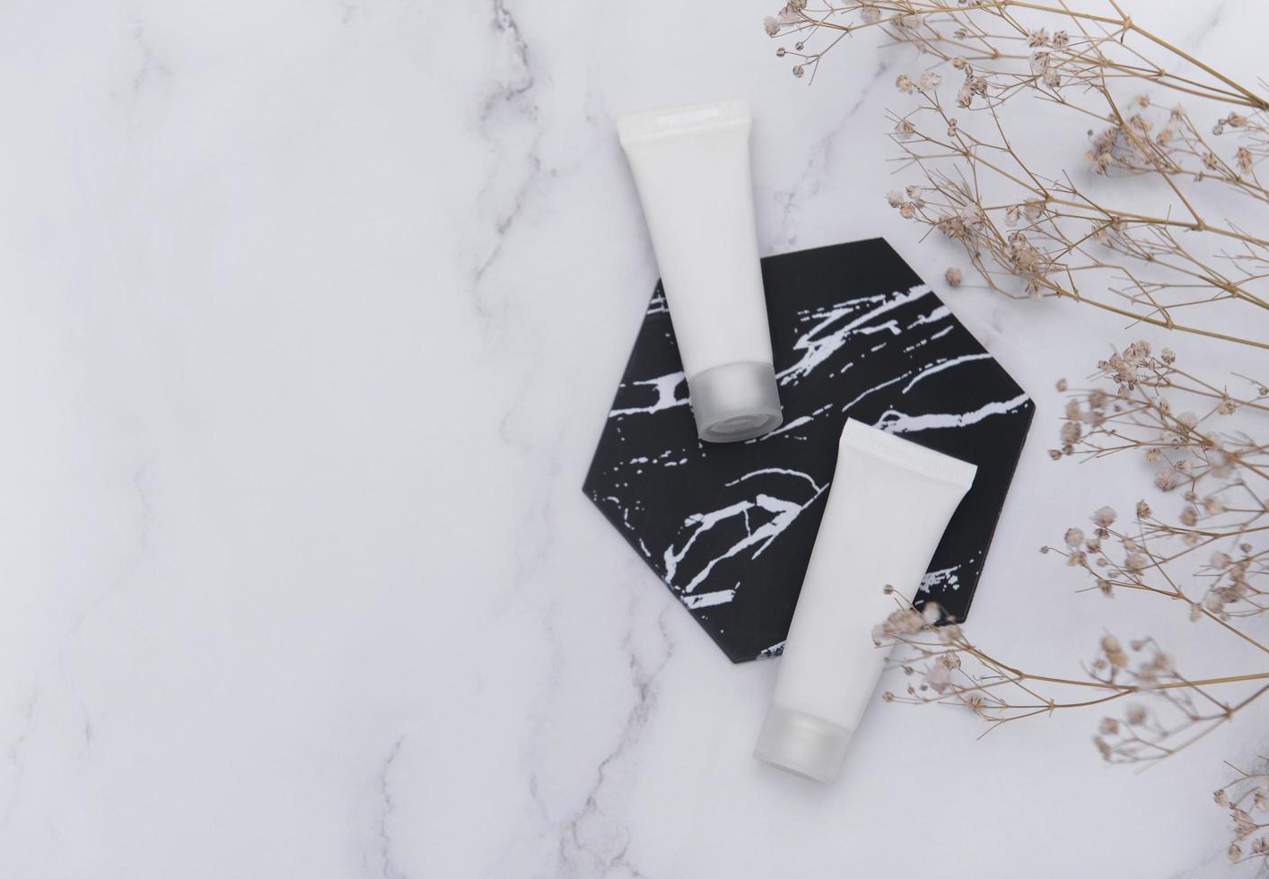 White tubes of cream on a marble background photo