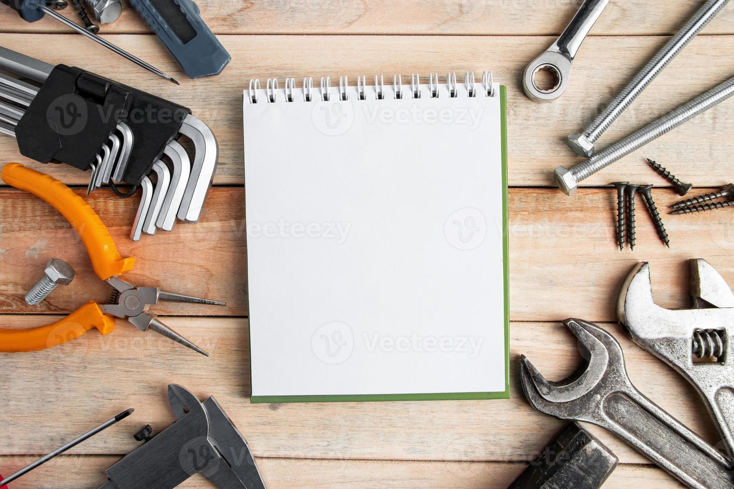 Set of work tools with a notepad on a wooden background photo