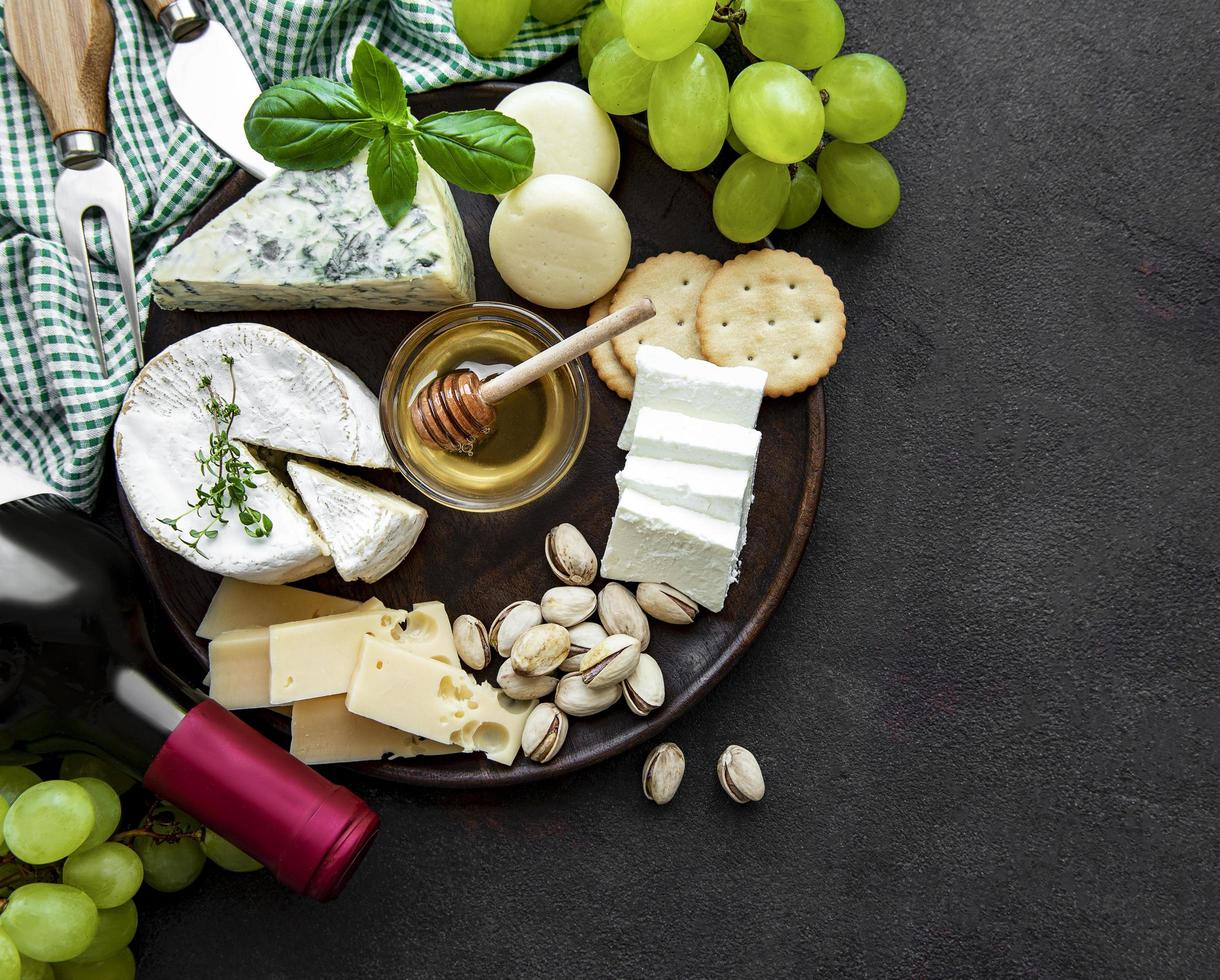 Various types of cheese, grapes and wine photo