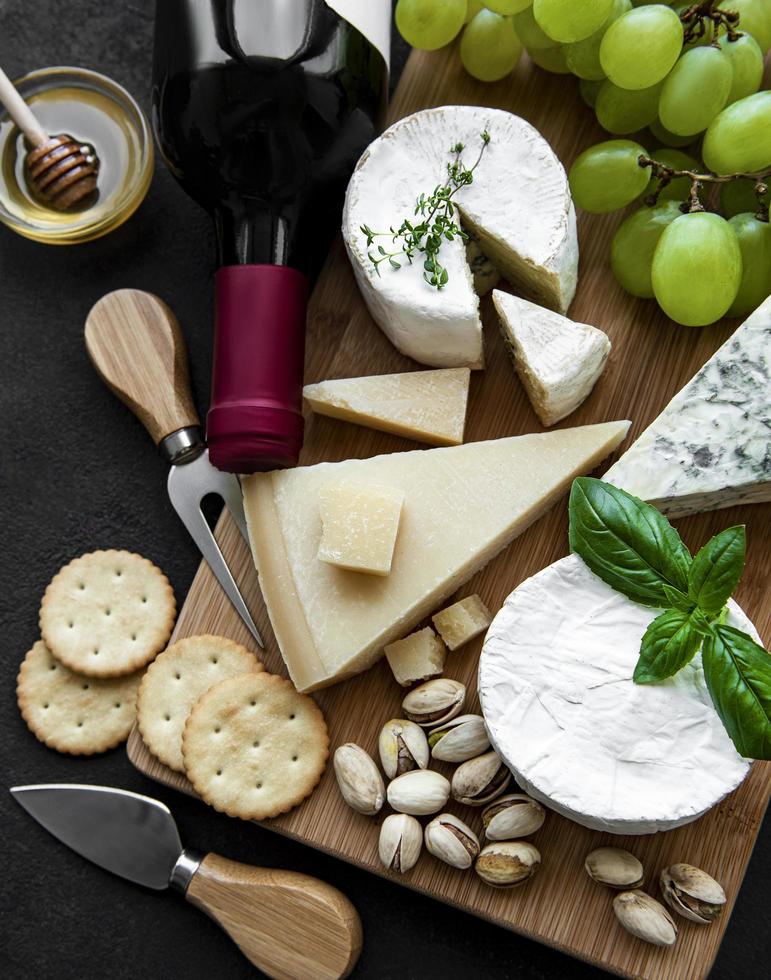 Various types of cheese, grapes and wine photo