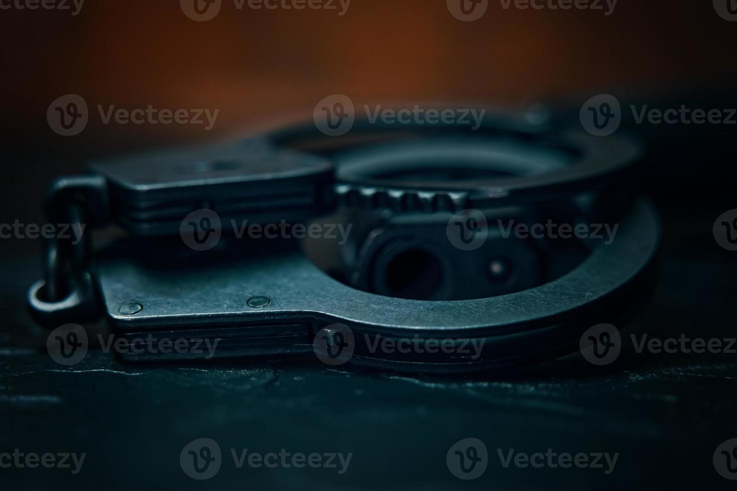 Handcuffs and the muzzle of a handgun close-up photo