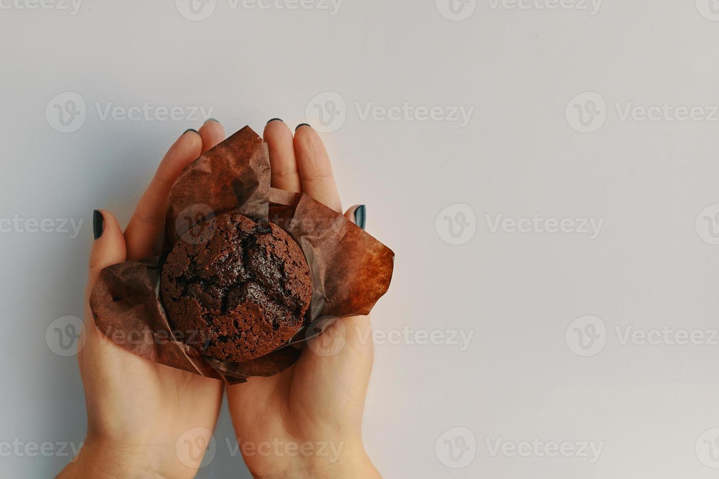 Top view of chocolate muffin in woman's hands photo