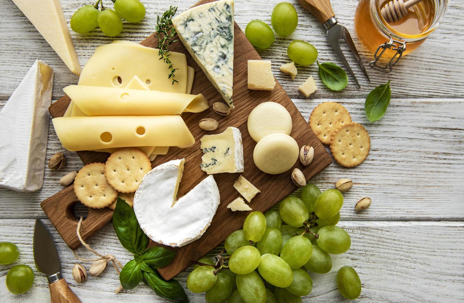 Various types of cheese on a white wooden background photo