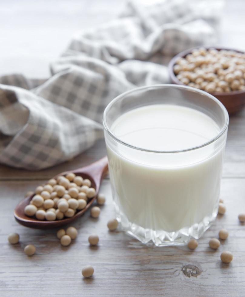 Leche de soja y soja en una mesa de madera. foto