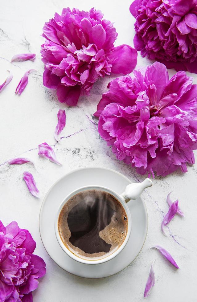 flores de peonía rosa y una taza de café foto