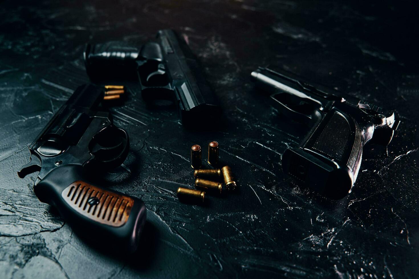 Tres pistolas y balas en el cuadro negro. foto