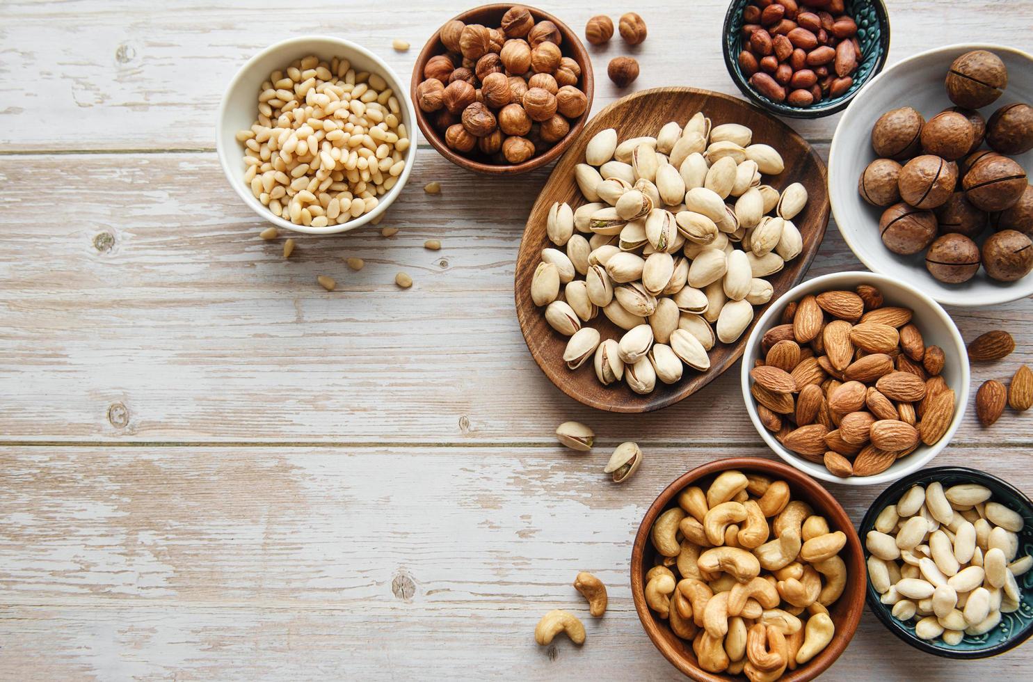 Bowls with various nuts on an old wooden background photo