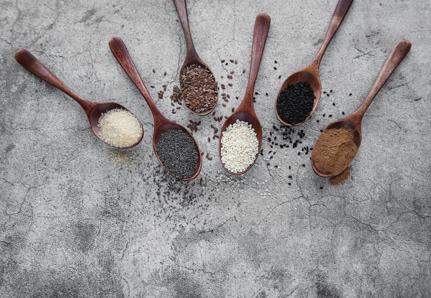 cucharas de madera con diversas semillas y especias saludables foto