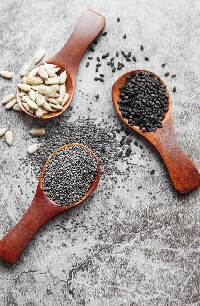 cucharas de madera con varias semillas saludables foto