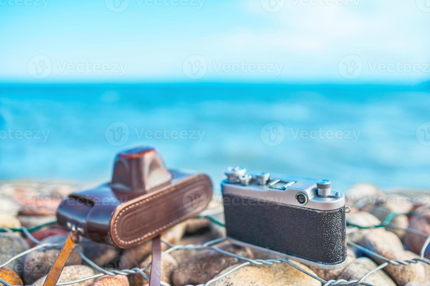 cámara en una valla de piedra contra el mar foto