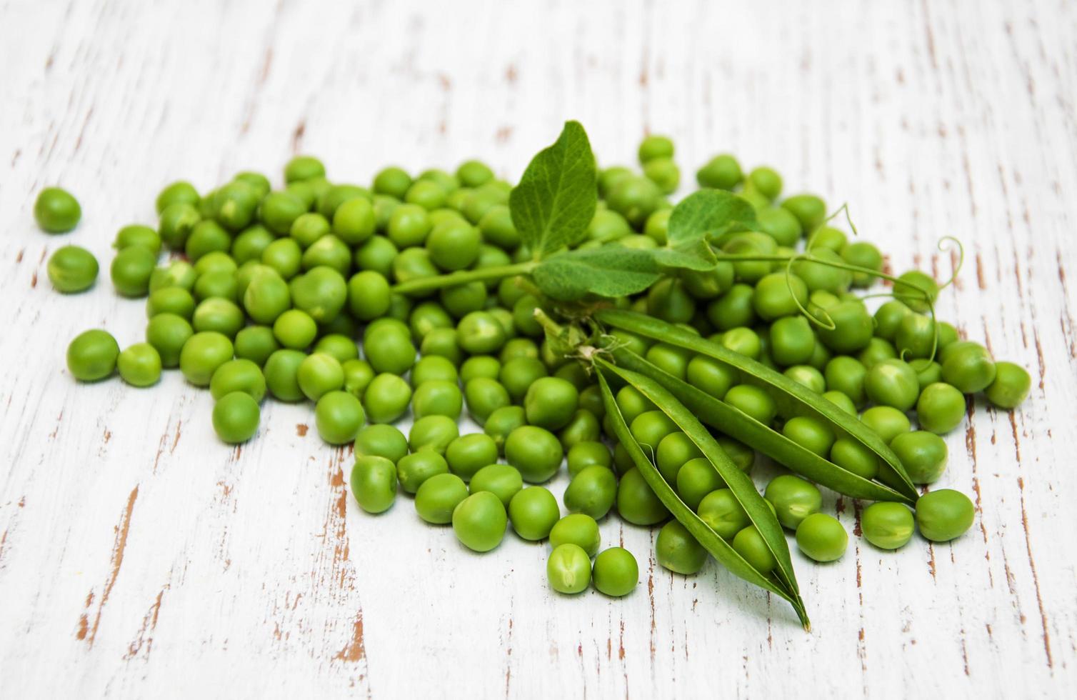 Guisantes con hojas sobre un fondo de madera vieja foto