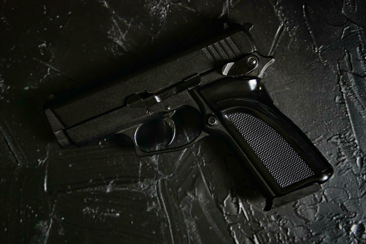 Gun on black texture table photo