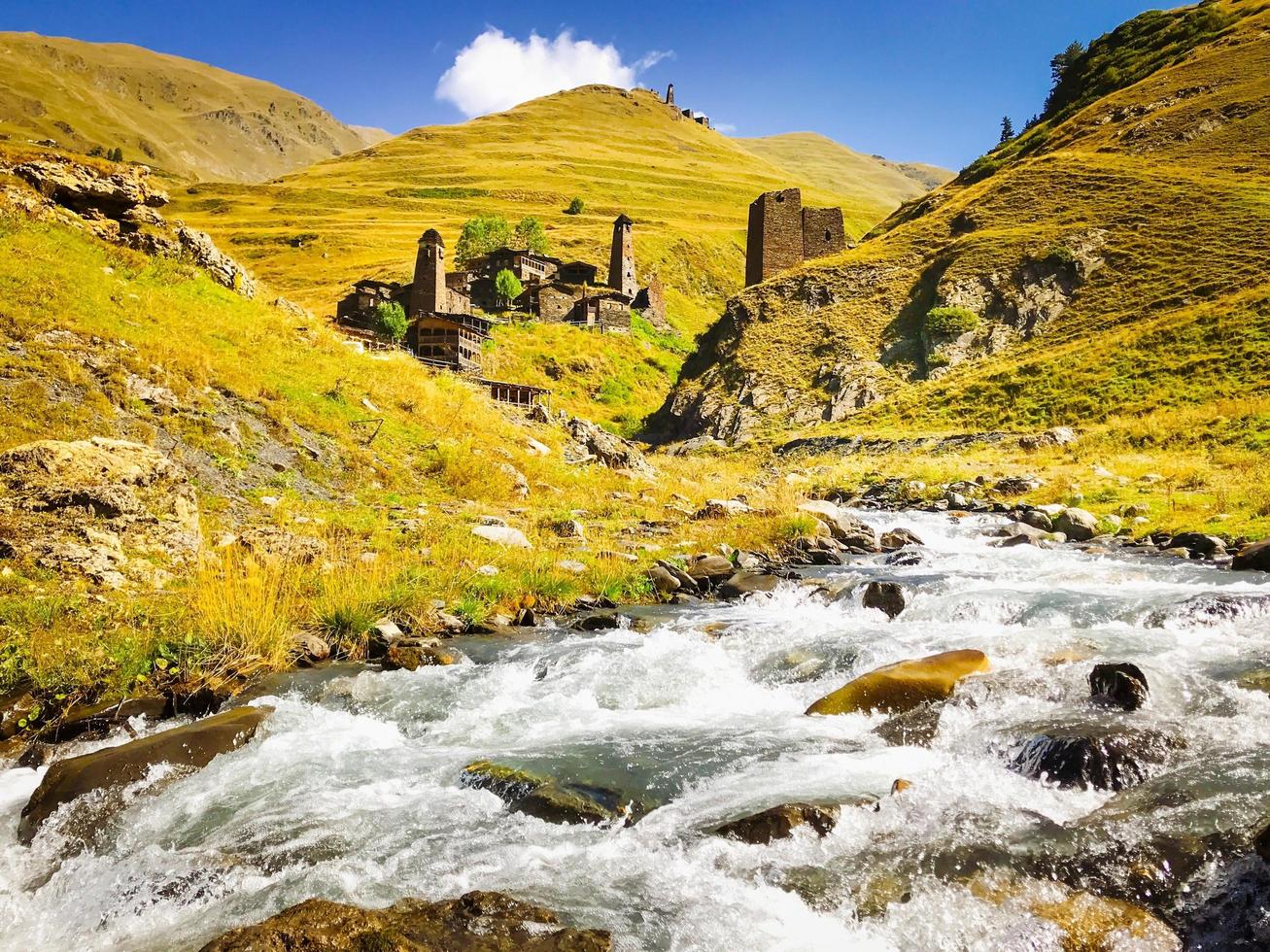 Panoramic view river and unique Dartlo village stone buildings and towers photo