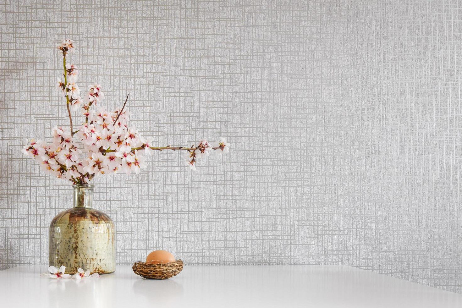 Decoración en la mesa de la cocina con margaritas de primavera, huevo de pascua y espacio en blanco en blanco foto