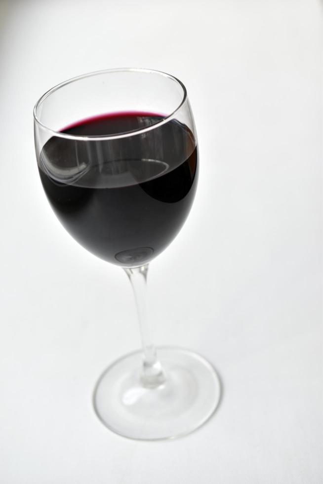 Large glass of red wine on a white background photo