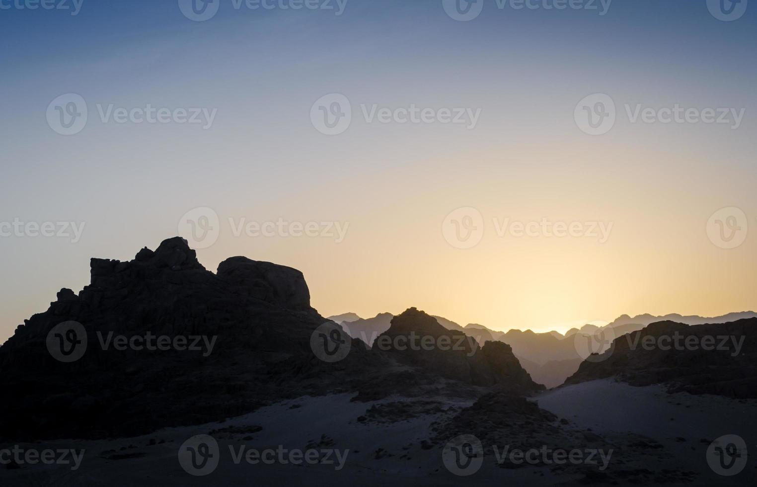 puesta de sol con siluetas de montañas rocosas foto