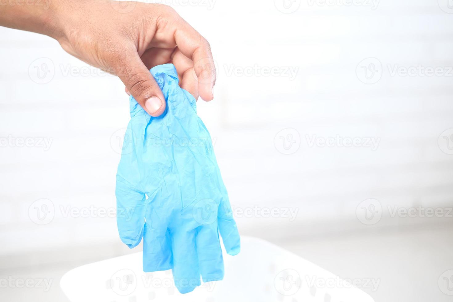 Disposing medical gloves in a bin photo