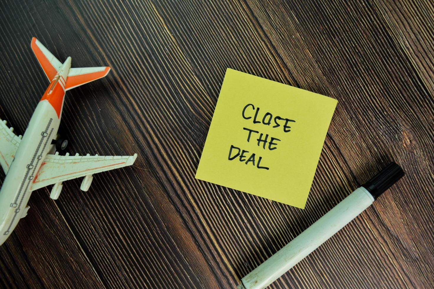 Close the deal written on sticky notes isolated on wooden table photo