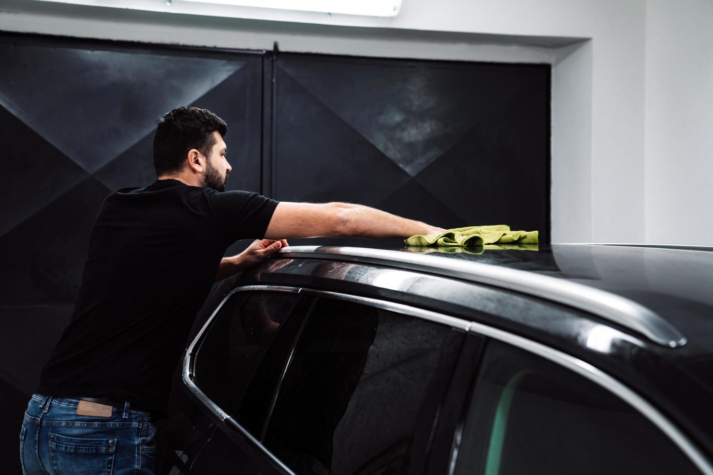 Man cleans the car body with a towel photo