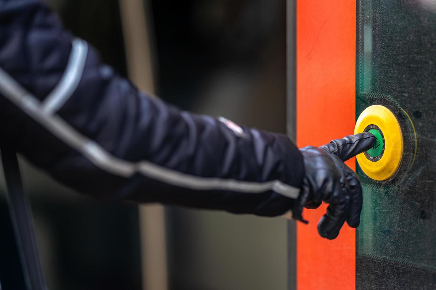 Mano presiona el botón de apertura de la puerta en el transporte público foto