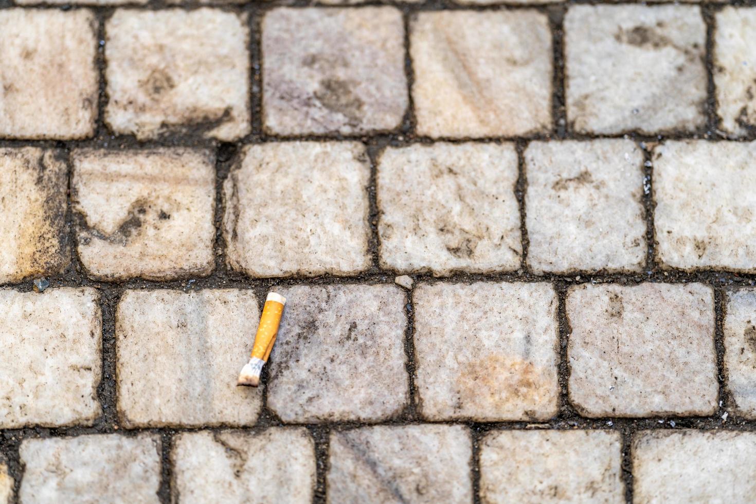 Cigarette butt on the sidewalk in the city photo