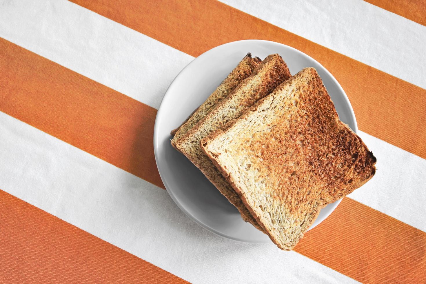 Dish with toast on tablecloth photo