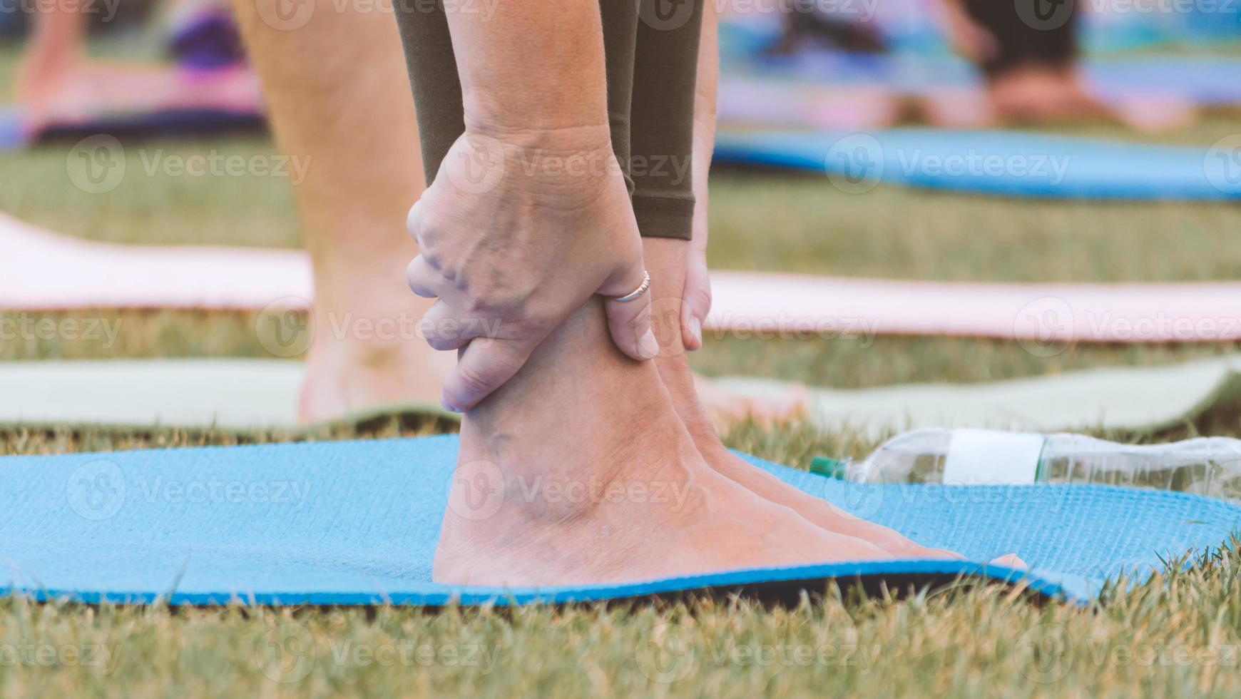 pies sobre una estera de yoga azul foto