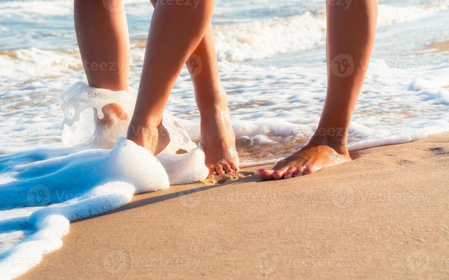 pies descalzos caminando en la playa foto
