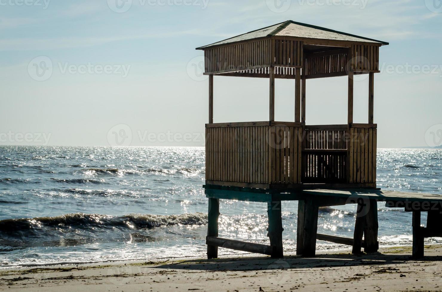 Cenador de madera sobre pilotes en la playa foto