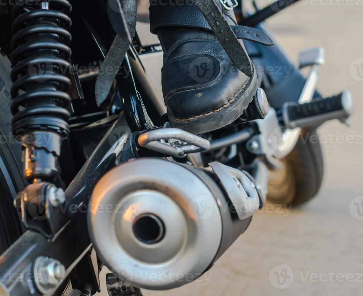 bota de motociclista en una motocicleta foto