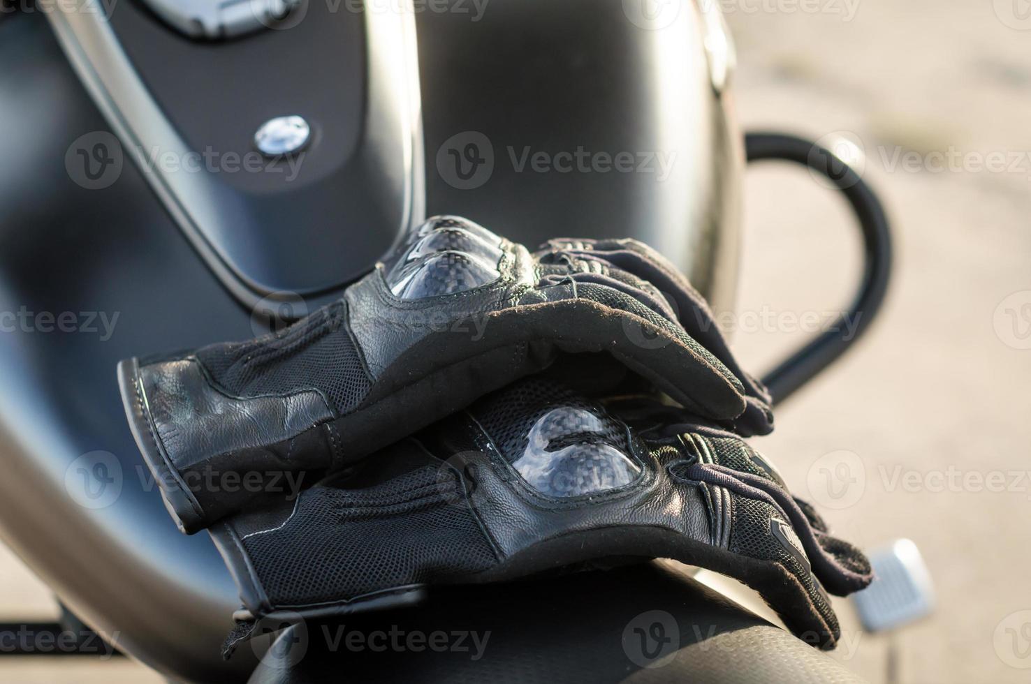 Guantes de motociclista en un asiento de motocicleta foto