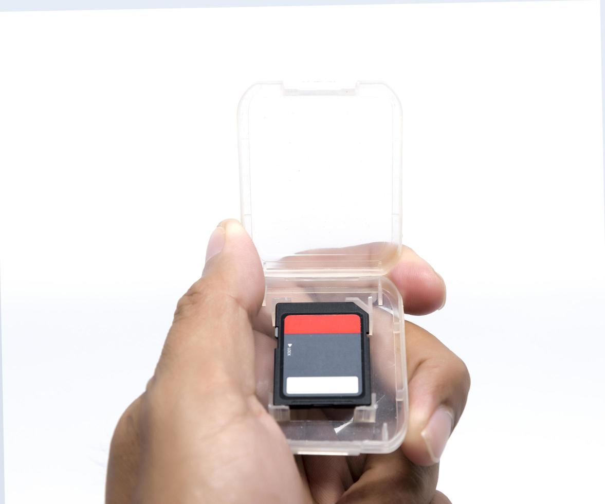 Hand holding compact flash memory card on white background photo
