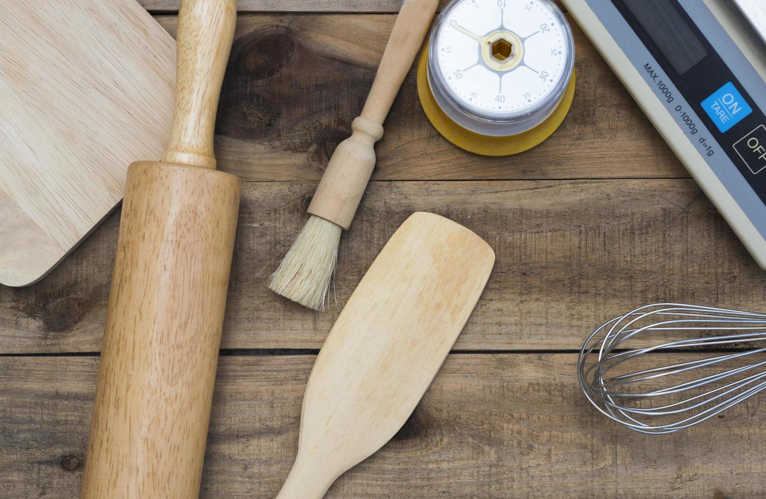 Panadería y utensilios de cocina con temporizador de cocina y básculas sobre una mesa de madera foto