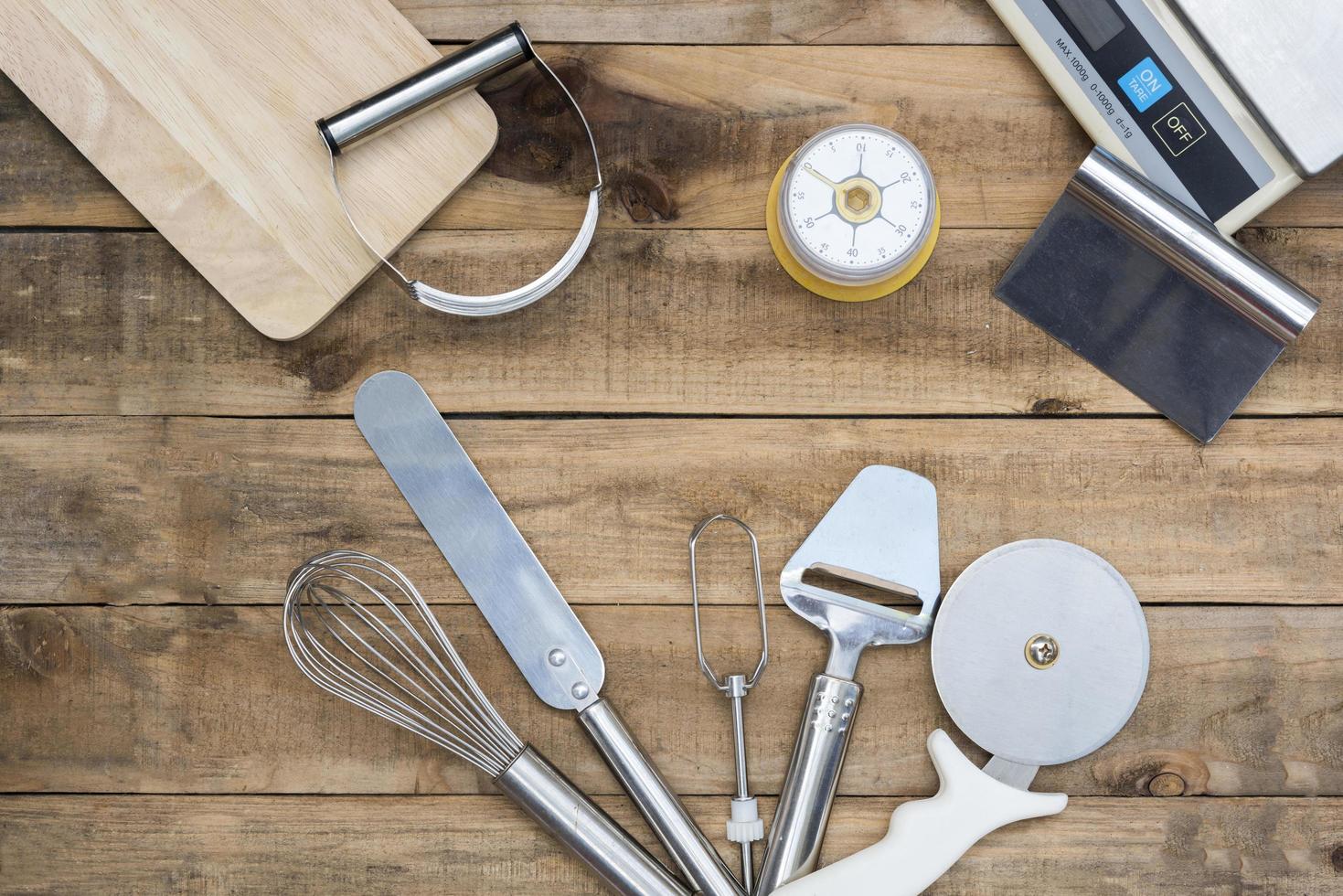 Bakery and cooking tools with kitchen timer and scales on a wood table photo