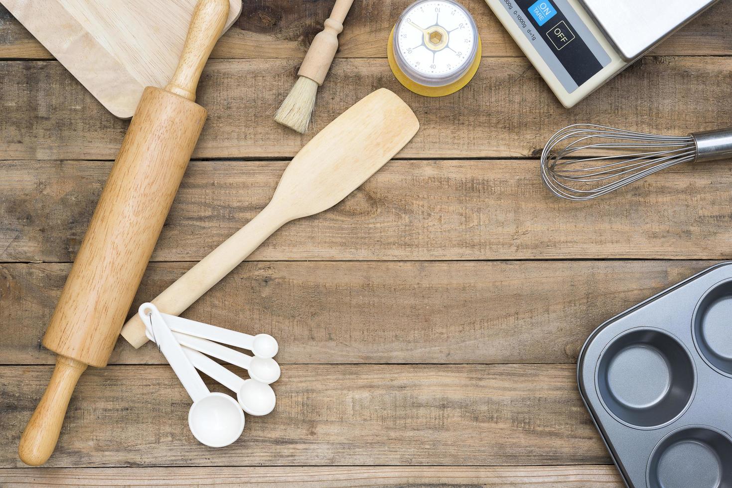 Panadería y utensilios de cocina con temporizador de cocina y básculas sobre una mesa de madera foto