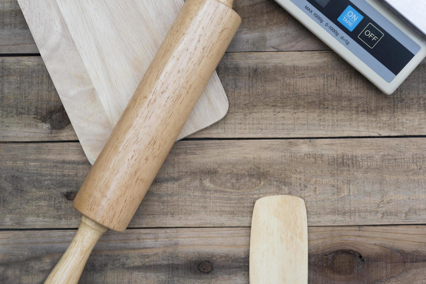 Herramientas de panadería de madera con una balanza digital sobre una mesa de madera foto