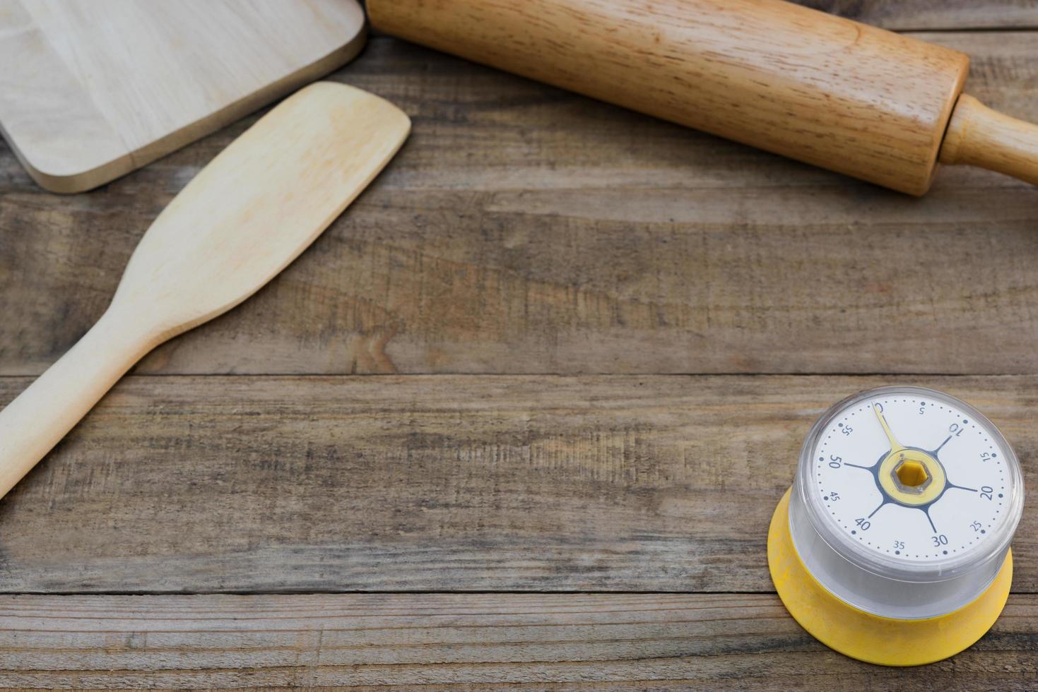 Panadería y utensilios de cocina con un temporizador de cocina sobre una mesa de madera foto