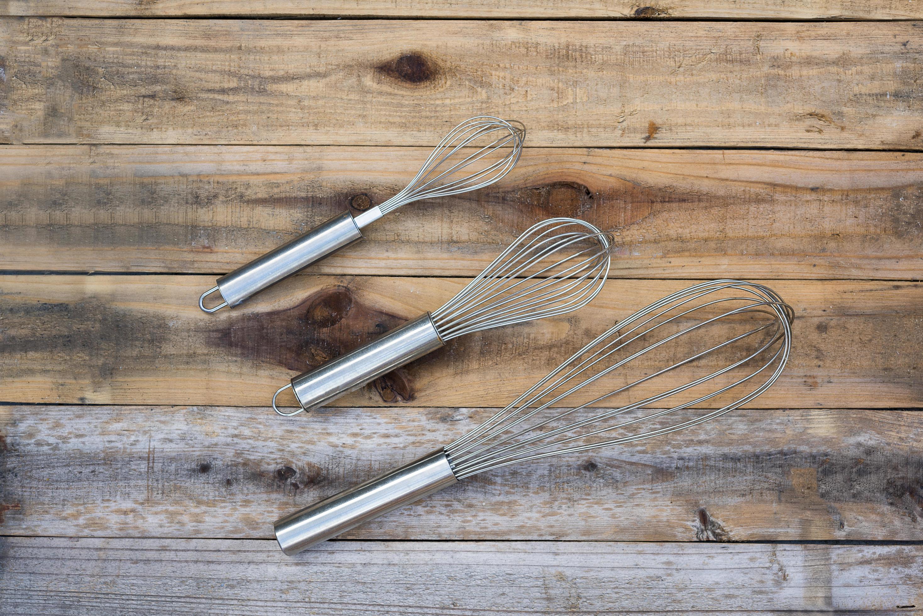 3 whisk different size on wood table 2221695 Stock Photo at Vecteezy