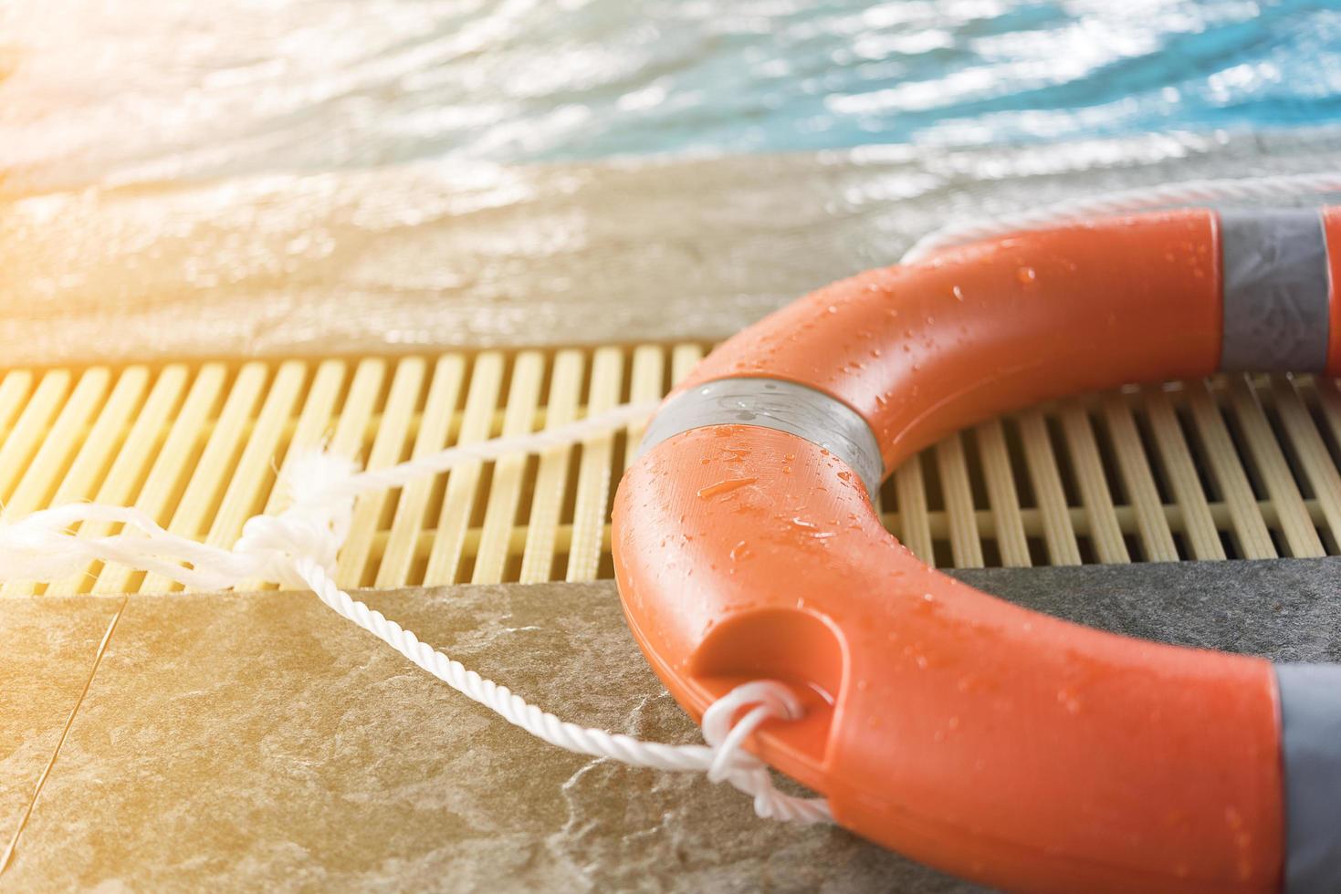 Dispositivo de flotación naranja junto a una piscina. foto