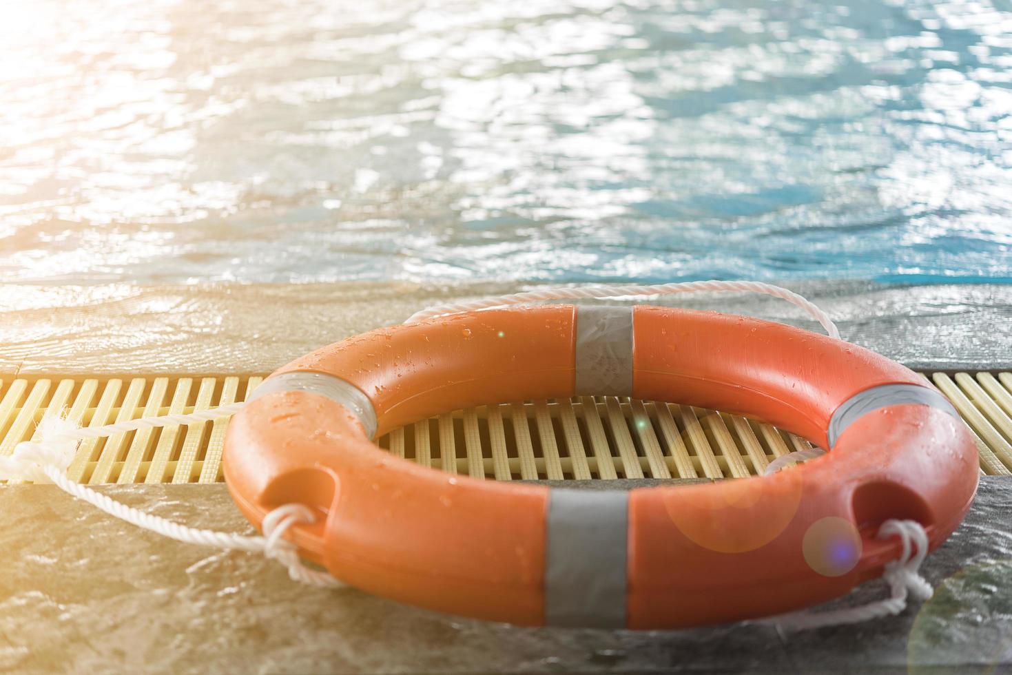 Dispositivo de flotación naranja junto a una piscina. foto