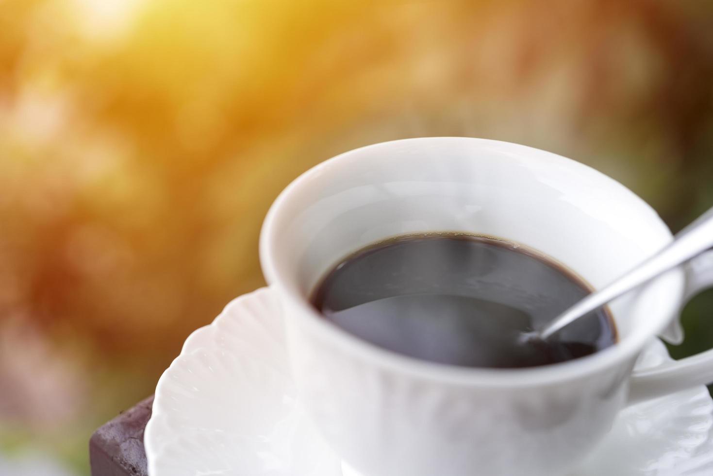 Close up of a cup of coffee with soft sunrays photo