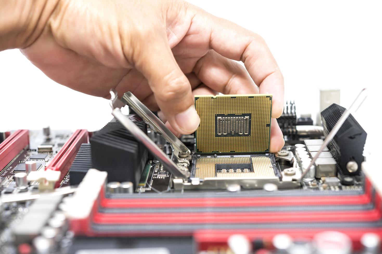 Hand holding a CPU and a motherboard socket for a CPU isolated on white background photo