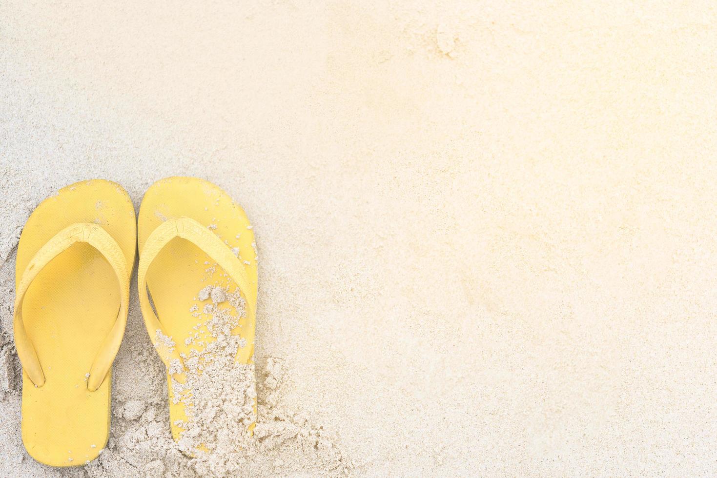 Yellow sandals on the beach during summer photo