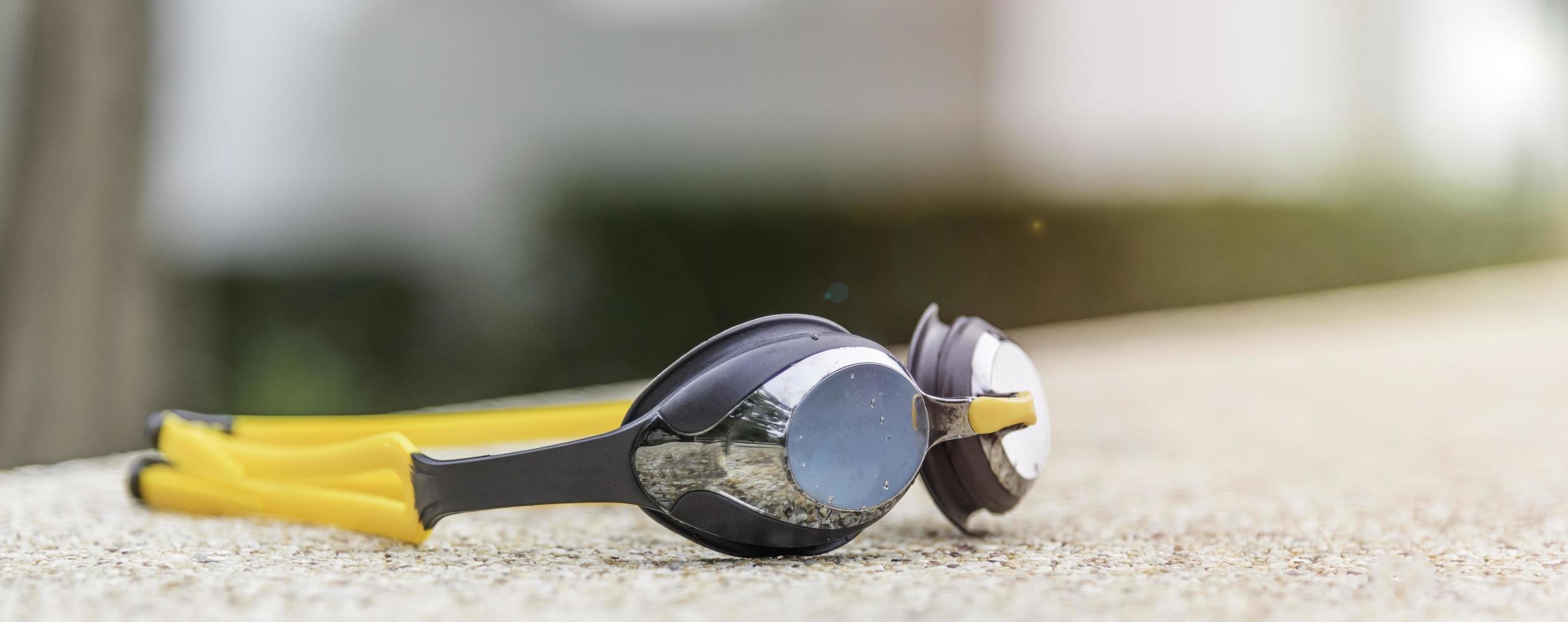 Goggles on the side of a swimming pool photo